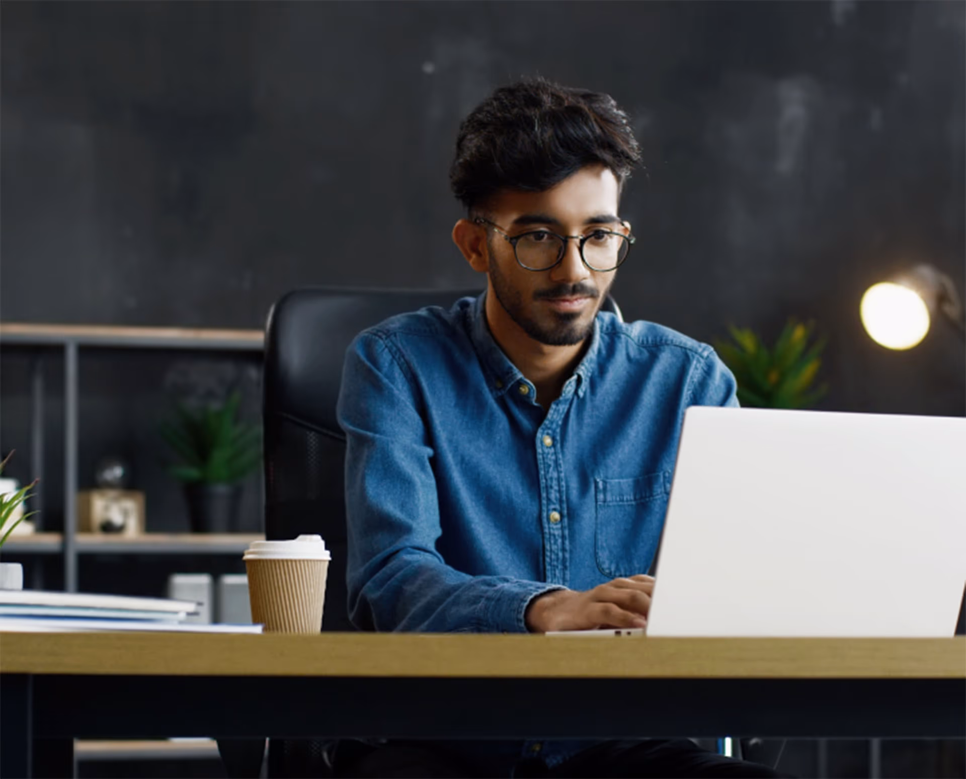 Person working on a laptop at a desk