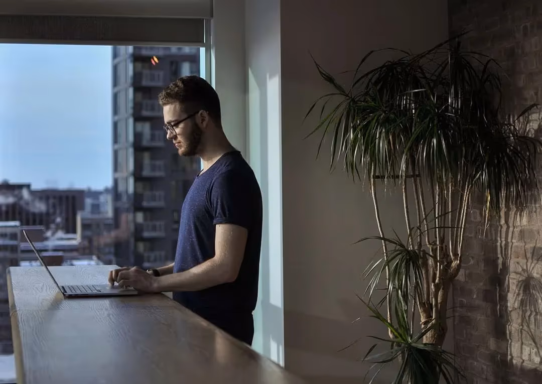 A DreamHost customer working on a laptop at a standing desk